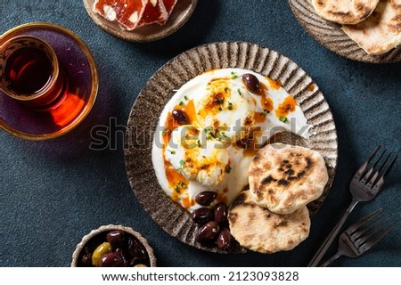 Cilbir or Turkish Eggs. mezze: poached eggs topped over herbed greek yogurt, then drizzled with hot spiced paprika olive oil. Traditional Turkish breakfast with rahat Stock photo © 