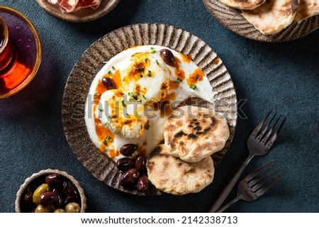 Cilbir or Turkish Eggs. mezze: poached eggs topped over herbed greek yogurt, then drizzled with hot spiced paprika olive oil. Traditional Turkish breakfast with rahat Stock photo © 