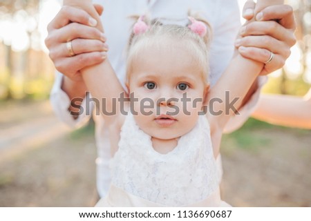 Cild emotion. Dad raises for the child's hands in front of him. Family in summer sunny park. stylish dad with kid relaxing in forest and smiling, having fun. space for text. family vacation