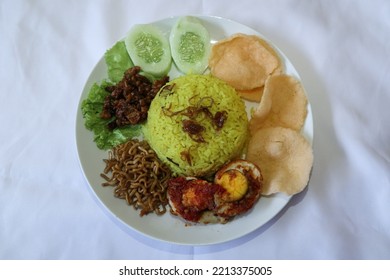 Cilegon, Indonesia  10 2022, A Serving Of Yellow Rice With A Side Dish Of Balado Eggs, Yellow Noodles, Orek Tempeh, Cucumber And Crackers. The Taste Is Savory, Spicy And Slightly Sweet.