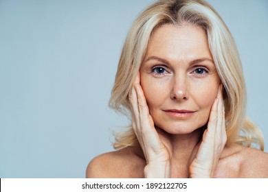 Cincematic Image Of A Beautiful Senior Woman Posing On A Beauty Photo Session. Middle Aged Woman In Lingerie On A Grey Background. Concept About Body Positivity, Self Esteem And Body Acceptance