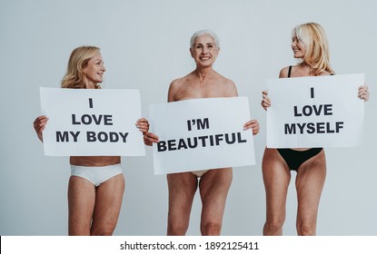 Cincematic Image Of A Beautiful Senior Woman Posing On A Beauty Photo Session. Middle Aged Woman In Lingerie On A Grey Background. Concept About Body Positivity, Self Esteem, And Body Acceptance