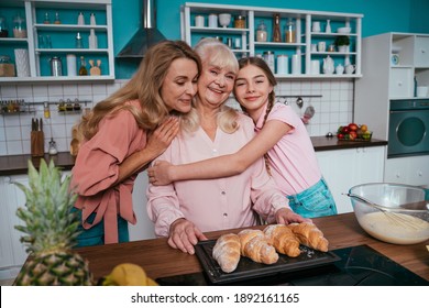 Cincematic image of a senior woman and her daughter and grandaugher baking and preparing food in her beautiful kitchen. Grandmother preparing cakes and sweets for the thanksgiving - Shutterstock ID 1892161165