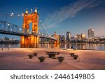 Cincinnati, Ohio, USA. Cityscape image of Cincinnati, Ohio, USA downtown skyline with the John A. Roebling Suspension Bridge and reflection of the city in the Ohio River at spring sunrise.