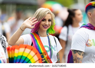 Cincinnati, Ohio, USA - June 22, 2019: The Cincinnati Pride Parade, Women With Rainbow Flags Wearing GLOW Shirts At The Parade