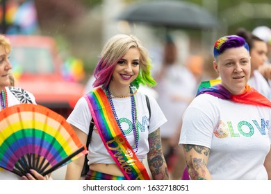 Cincinnati, Ohio, USA - June 22, 2019: The Cincinnati Pride Parade, Women With Rainbow Flags Wearing GLOW Shirts At The Parade