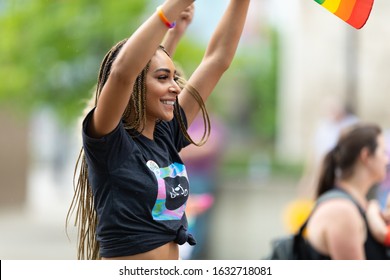 Cincinnati, Ohio, USA - June 22, 2019: The Cincinnati Pride Parade, Young Women Waving The Rainbow Flag, Promoting Oggo