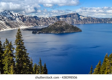 A Cinder Cone Island Stands In The Sky Blue Waters Of Crater Lake, Oregon.