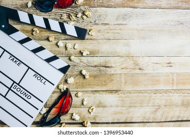 Cinema background. Clapperboard, pop corn and 3d glasses in a wooden background..Flat lay .party concept