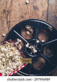 Cinema Concept With Vintage Film Reel, Popcorn And A Movie Ticket