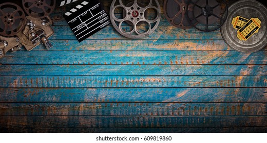 Cinema Concept Of Vintage Film Reels, Clapperboard And Projector On Old Wooden Background.