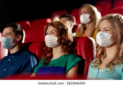 cinema, entertainment and pandemic concept - people wearing face protective medical masks for protection from virus disease watching movie in theater - Powered by Shutterstock