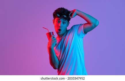 At Cinema, Movie. Stylish Young Asian Man Isolated Over Lilac Color Studio Background In Pink Neon Light. Concept Of Human Emotions, Facial Expression, Youth Culture, Diversity