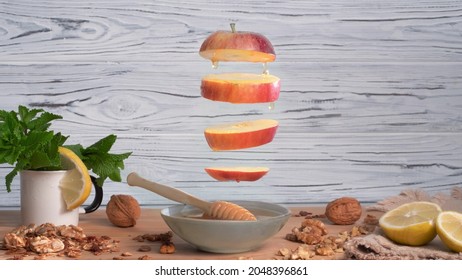 Cinemagraph - Apple slices with honey dripping. Appetizing still-life with walnuts, mint and lemon