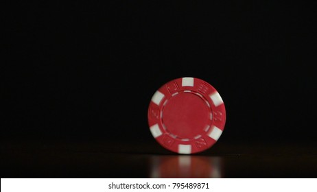 Cinemagraph - Rotation of poker chips on the table isolated on black background. Poker chips shaffling. Poker chip spinning on the table isolated on dark background