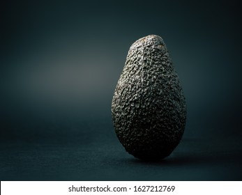 Cinematic Avocado Studio Photography, Isolated On A Dark Background Showing A Rough And Bumpy Texture