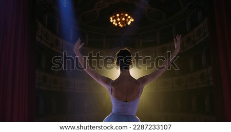 Cinematic Back View of Young Graceful Classical Ballet Female Dancer Entering the Stage of Classic Theatre with Dramatic Lighting. Professional Female Performer Rehearsing Alone Before the show