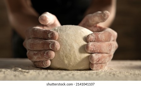Cinematic close up of professional artisan baker chef is making with flour loaf of dough for preparation of pasta, pizza and other pastries in rustic bakery kitchen. - Shutterstock ID 2141041107