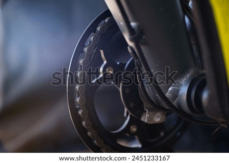Cinematic close-up view of the main chainring of a bicycle, showing the links of the bicycle chain, slightly dirty.