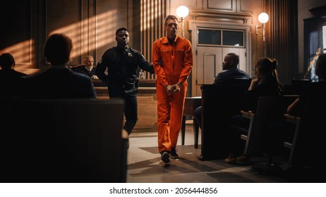 Cinematic Court of Law and Justice Trial Proceedings: Portrait of Accused Sad Male Criminal in Orange Jumpsuit Led Away by Security Guard in Front of Judge and Jury. Sentenced to Serve Jail Time.