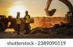 Cinematic Golden Hour Shot Of Construction Site: Caucasian Male Civil Engineer And Hispanic Female Architect Talking And Using Tablet. Trucks, Excavators, Loaders Working To Build New Apartment Block.