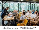 Cinematic image of a conference meeting. Business people sitting in a room listening to the motivator coach. Representation of a Self growth and improvement special event
