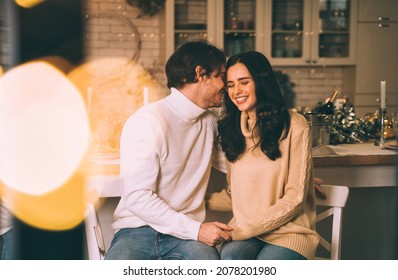 Cinematic Image Of A Couple Celebrating Christmas At Home. Boyfriend And Girlfriend Spending Time Together On The New Year Evening And Sharing Positive Vibes. 