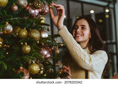 Cinematic image of a woman celebrating christmas at home. Boyfriend and girlfriend spending time together on the new year evening and sharing positive vibes. 