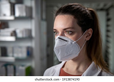 Cinematic Macro Shot Of Female Pharmacist Consultant With Protective N95 Respirator Mask Is Looking Outside In Pharmacy. Concept Of Covid-19, Protection, Coronavirus,prevention, Safety, Health Care.