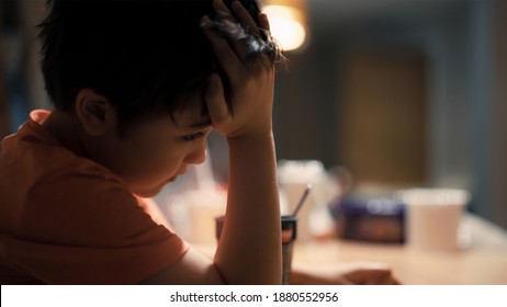 Cinematic Portrait Of Lonely Little Boy Siting Alone In Dinning Table, Sad Kid Puting His Head Down On His Hand Looking Deep In Through, Bored Child Haivng Dinner Alone With Dramatic Light.