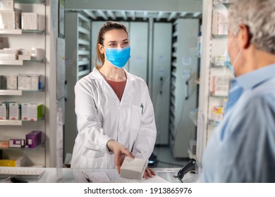 Cinematic Shot Of Pharmacist Consultant With Protective Face Mask Handing Over Prescribed Medicines To Patient In Pharmacy. Concept Of Covid-19, Protection, Virus Transmission,drug Store,assistance.