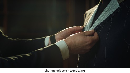 Cinematic shot of professional tailor taking measurements for creation of custom high quality tailored suit in luxury tailoring atelier.Concept of fashion, handmade, hand craft, couturier and business