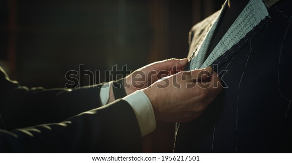 Cinematic shot of professional tailor taking\
measurements for creation of custom high quality tailored suit in\
luxury tailoring atelier.Concept of fashion, handmade, hand craft,\
couturier and\
business