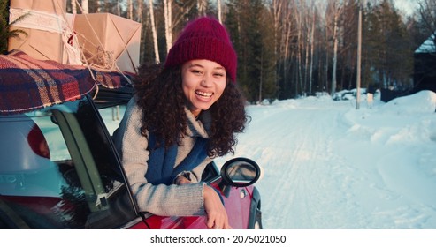 Cinematic Shot, Three Happy Young Beautiful Multiethnic Women Wave At Camera In Red Car On Snowy Winter Road Slow Motion