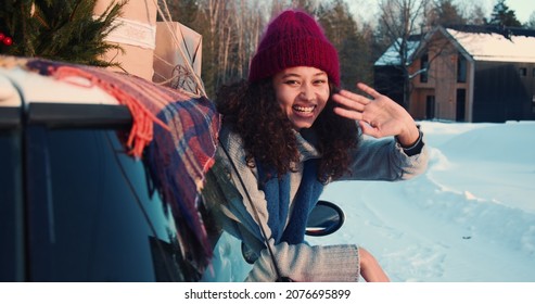 Cinematic Shot, Three Happy Young Beautiful Multiethnic Women Wave At Camera In Red Car On Snowy Winter Road Slow Motion