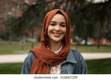Cinematic shot of young happy Arabian muslim woman wearing hijab is smiling  in camera outdoors. - Shutterstock ID 2136427239