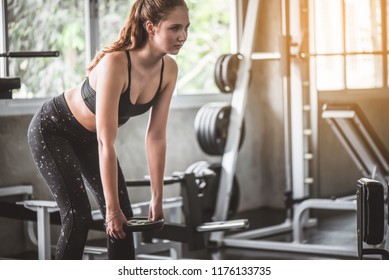 Cinematic tone of young attractive fitness woman exercise with machine in gym. Individual sport to fit muscles of body for healthy life concept.