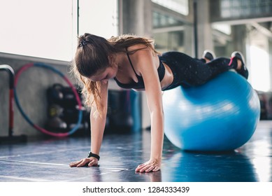 Cinematic tone of young attractive fitness woman exercise with ball in gym. Individual sport to fit muscles of body for healthy life concept.
