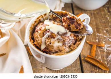Cinnabon cake in mug. Fast simple microwave dessert idea, background for recipe. Cinnamon roll mugcake, with sugar and cream cheese topping, in different mugs, with cinnamon sticks - Powered by Shutterstock