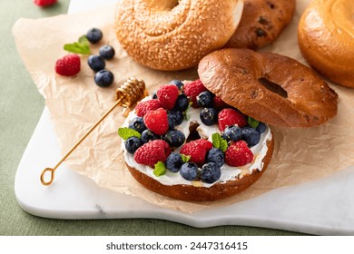 Cinnamon bagel with cream cheese, fresh berries and honey for breakfast - Powered by Shutterstock