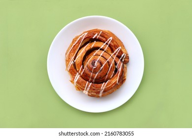 Cinnamon Roll Croissant Served On Plate Isolated On Green Background