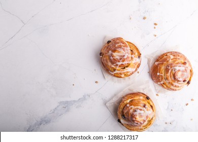 Cinnamon Rolls Buns On A White Marble Background. Bakery Concept. Breakfast And Brunch. Flatlay. Overhead. Copy Space