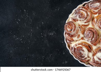 Cinnamon Rolls Cooked in Round Baking Dish Copyspace Flat Lay Photo. Classic Freshly Cook Delicious Cinnamon Biscuit Bread Pastries Covered Baked Milk Glaze. Cookies Dessert on Confectioner Desk