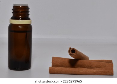 Cinnamon stick and aromatherapy oil with white background