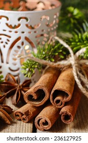 Cinnamon sticks and anise stars on christmas table. Beautiful candle holder in the background - Shutterstock ID 236127925