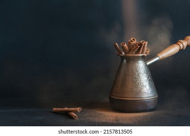 Cinnamon sticks in a cezve on a dark spotted background with cinnamon spice dust. Selective focus with a lot of space - Shutterstock ID 2157813505