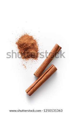 Cinnamon sticks and grounded cinnamon isolated on a white background. Cinnamon spice powder viewed from above. Top view.