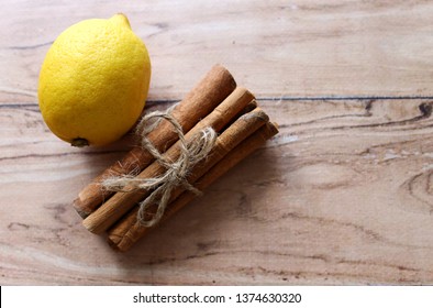 Cinnamon sticks and a lemon on a wooden background - Powered by Shutterstock