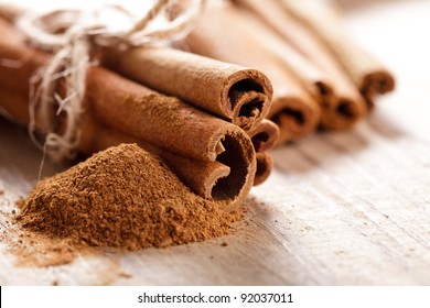 Cinnamon sticks and meal close up on wooden table