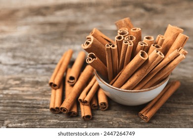 Cinnamon sticks on a textured wooden background. Cinnamon roll. Spicy spice for baking, desserts and drinks. Fragrant ground cinnamon. cinnamon powder Close-up. Place for text. copy space - Powered by Shutterstock